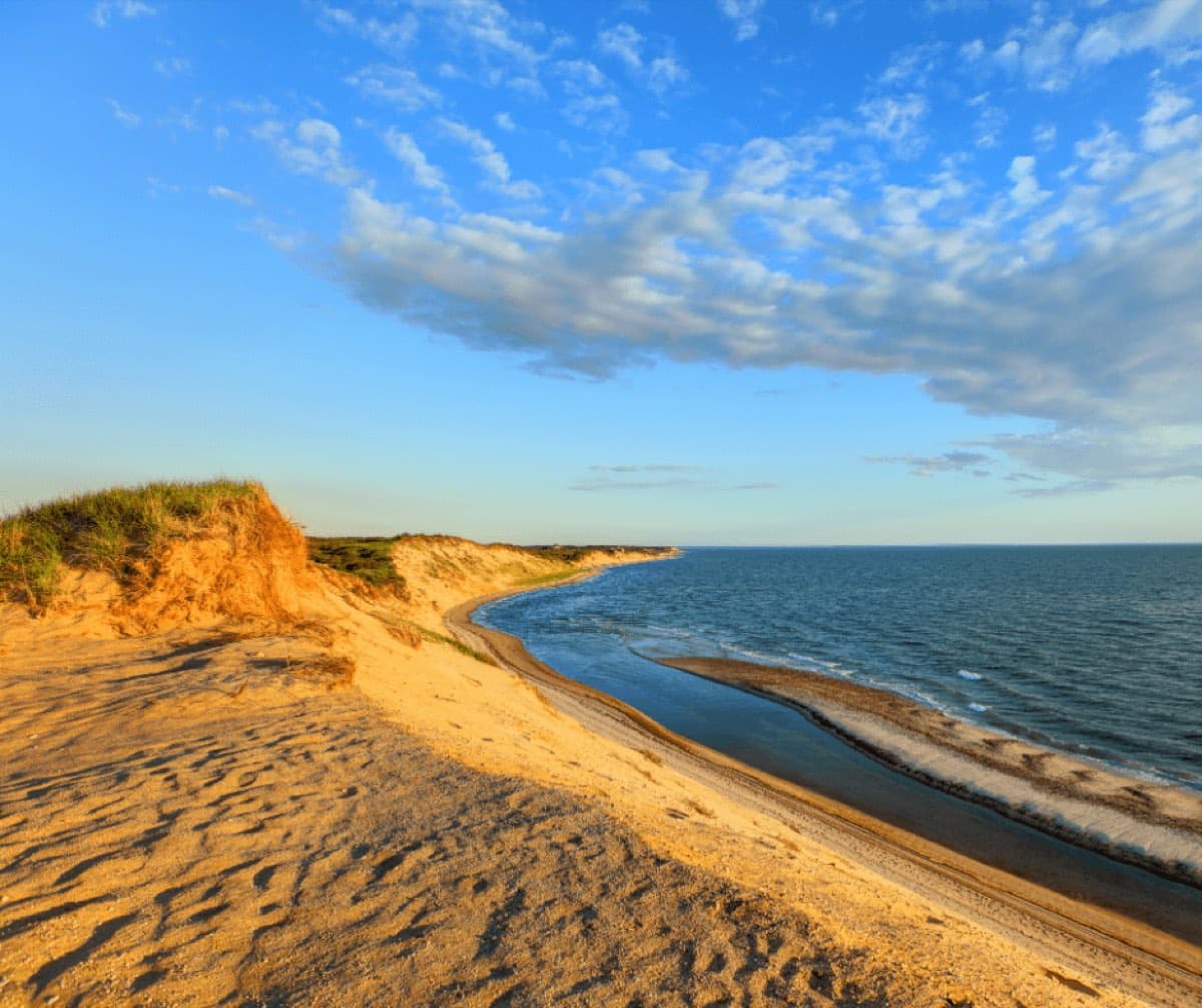 Sandy coastal bluff and beach above the ocean in evening light